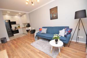 een woonkamer met een blauwe bank en een tafel bij Loft Apartament 1 in Gorzów Wielkopolski