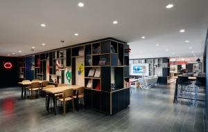a library with tables and chairs and a book shelf at citizenM Kuala Lumpur Bukit Bintang in Kuala Lumpur