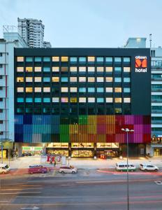 a building with colored windows and cars parked in a parking lot at citizenM Kuala Lumpur Bukit Bintang in Kuala Lumpur