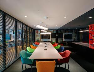 a conference room with a long table and colorful chairs at citizenM Kuala Lumpur Bukit Bintang in Kuala Lumpur