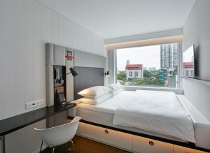 a bedroom with a large bed and a window at citizenM Kuala Lumpur Bukit Bintang in Kuala Lumpur