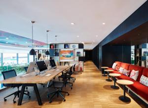 an office with a long table and chairs and a couch at citizenM Kuala Lumpur Bukit Bintang in Kuala Lumpur