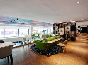 a living room with green chairs and a table at citizenM Kuala Lumpur Bukit Bintang in Kuala Lumpur