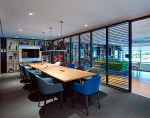 a dining room with a large wooden table and blue chairs at citizenM Kuala Lumpur Bukit Bintang in Kuala Lumpur
