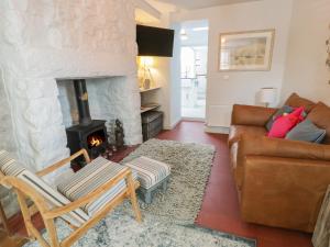a living room with a couch and a fireplace at Llawenfan in Criccieth