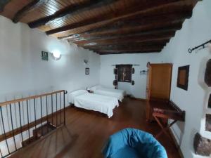 a living room with two beds and a wooden ceiling at Casa los Abuelos in El Pinar del Hierro