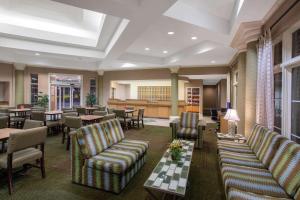 un restaurante con sofás, mesas y sillas en La Quinta by Wyndham Denver Southwest Lakewood en Lakewood