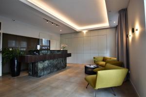 a lobby with yellow chairs and a reception desk at Hotel Impresja in Gdańsk