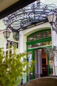 una tienda frente con una puerta verde y luces en Hotel Kutko, en Pančevo