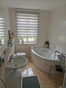 a bathroom with a large tub and a sink at Alleeblick in Ballenstedt