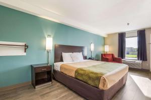 a hotel room with a bed and a chair at Econo Lodge Inn & Suites I-65 in Brooks