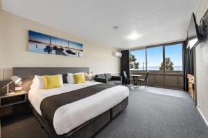 a bedroom with a large bed and a living room at Bayside Hotel in St Helens