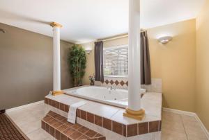 a large bathroom with a tub and a window at Econo Lodge Inn & Suites Bryant in Bryant