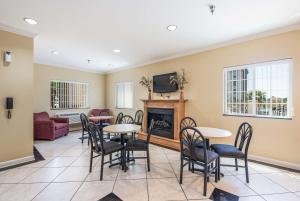 a living room with tables and chairs and a fireplace at Econo Lodge Inn & Suites Bryant in Bryant