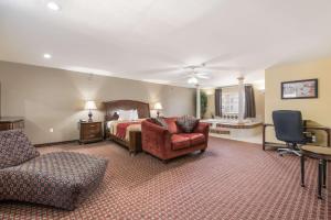 a bedroom with a bed and a couch and a chair at Econo Lodge Inn & Suites Bryant in Bryant