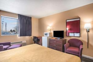 Habitación de hotel con 1 cama, 2 sillas y TV en Econo Lodge en Princeton