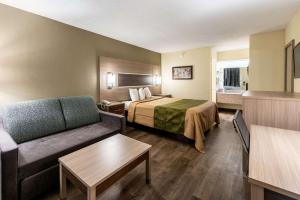 a hotel room with a bed and a couch at Econo Lodge Vicksburg in Vicksburg