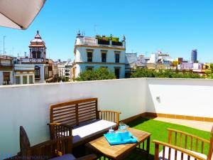 un patio con mesa y sillas en la azotea en ALAMEDA SQUARE APARTMENT, en Sevilla