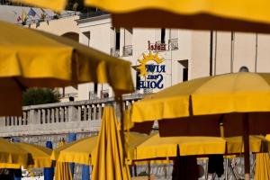 a group of yellow umbrellas in front of a building at Hotel Riva Del Sole in Cefalù