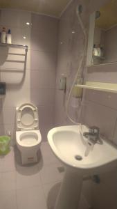 a white bathroom with a sink and a toilet at Kenting Heng-Chung Art Hostel in Hengchun
