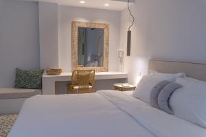 a bedroom with a bed and a mirror and a chair at Adonis Hotel Studios & Apartments in Naousa