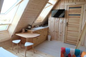 a kitchen in a tiny house with a tv at TuDobrze Noclegi w piramidach in Borzytuchom