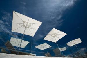 um grupo de guarda-chuvas brancos no topo de um edifício em Adonis Hotel Studios & Apartments em Naousa