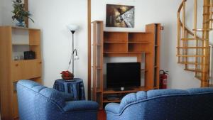 un salon avec deux chaises bleues et une télévision dans l'établissement Casa Azul (Blue House), à Urzelina
