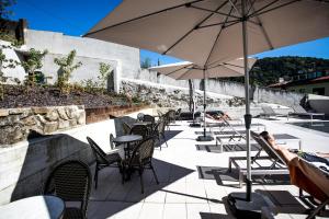 een patio met stoelen, tafels en parasols bij Villa Eugenia Boutique Hotel in San Sebastian