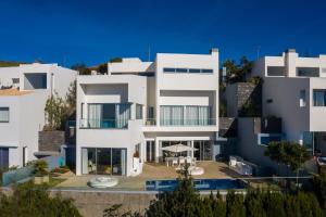 une maison blanche avec une piscine en face de celle-ci dans l'établissement Luxury villa Carlota with private pool by HR Madeira, à Caniço