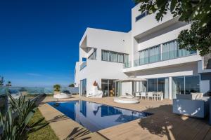 - une vue sur l'extérieur d'une maison avec une piscine dans l'établissement Luxury villa Carlota with private pool by HR Madeira, à Caniço