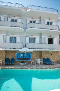a hotel with a swimming pool in front of a building at Limani Apartments in Kassiopi