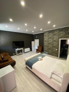 um quarto com uma grande cama branca e uma televisão em Arizet Boutique Mamaia em Mamaia