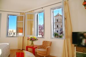 Habitación con ventanas, silla y torre. en Operetta House, en Lárnaca