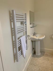 a white bathroom with a sink and a mirror at High Street Flat in Sherborne