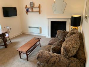 ein Wohnzimmer mit einem Sofa und einem Tisch in der Unterkunft High Street Flat in Sherborne