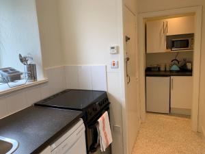 uma pequena cozinha com um fogão e um lavatório em High Street Flat em Sherborne