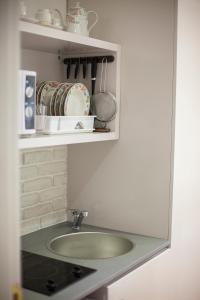 a kitchen with a sink and a shelf with dishes at Operetta House in Larnaca