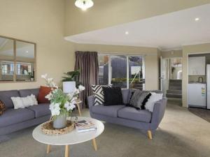 a living room with two couches and a table at ULTIMATE CONVENIENCE, WALK-TO-TOWN TOWNHOUSE in Queenstown