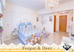 Un dormitorio con una cama azul y una lámpara de araña. en Forest Deer Black Tea Homestay en Tainan