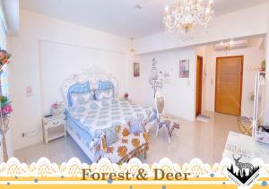 a bedroom with a blue bed and a chandelier at Forest Deer Black Tea Homestay in Tainan