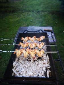 a grill with shrimp and other food on it at Kryzbarkas in Degučiai