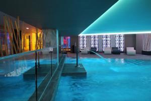 una gran piscina de agua azul en un edificio en Hotel Spa Porta Maris by Melia, en Alicante