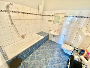 ein Badezimmer mit einer Badewanne, einem WC und einem Waschbecken in der Unterkunft Business Apartment near Neuss/Düsseldorf in Korschenbroich