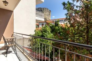 a balcony with a chair and a view of a city at Toti Boutique Rooms in Kalabaka