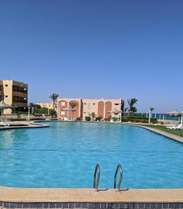 a large swimming pool with two metal handles in front of a building at Ain El Sokhna ground floor, with Pool & Sea view in Ain Sokhna