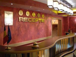 a restaurant with a table and clocks on the wall at Hotel Sud in Giurgiu