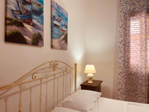 sypialnia z łóżkiem i dwoma obrazami na ścianie w obiekcie Kasbah San Francesco w mieście Mazara del Vallo
