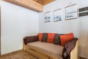ein Sofa in einem Zimmer mit Bildern an der Wand in der Unterkunft Appartamento Adamello 15 in Pinzolo