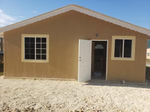 une petite maison marron avec une porte blanche dans l'établissement Montego Bay Home Close to Resort Area and Airport, à Montego Bay